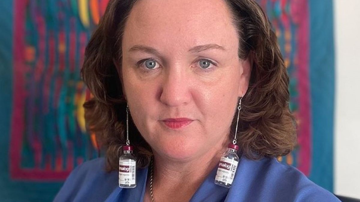 Katie Porter wearing earrings made from old insulin vials .